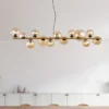 Pendelleuchte RIHA Messing-Schwarz 13-flammig mit Glaskugeln Bernstein, B: 120cm